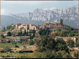 a town on a hill with a mountain in the background at Apartamentos Rurales La Pikurutza in Bernedo