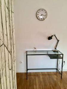 Lisbon Woods House في لشبونة: مكتب في غرفة مع ساعة على الحائط