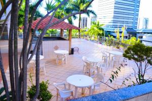 a patio area with tables, chairs and umbrellas at ABC Apart Hotel in Brasilia