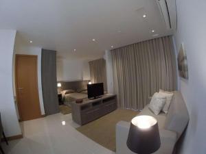 a living room with a couch and a television at Samba Rio Convention & Residence in Rio de Janeiro