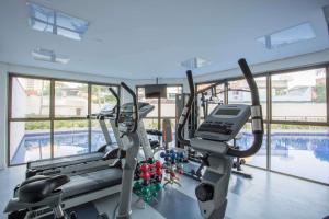 a gym with two tread machines and a swimming pool at Samba Rio Convention & Residence in Rio de Janeiro