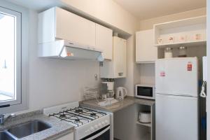 cocina con electrodomésticos blancos y nevera blanca en Nueva Córdoba Duomo en Córdoba