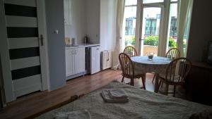 a room with a table and chairs and a kitchen at Sopotkowo Centrum in Sopot