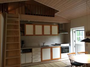 a kitchen with a loft bed and a table with chairs at LindegaardApartment - woods and sea in Hejls +21 photos