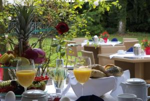 een tafel met twee glazen sinaasappelsap en brood bij Concorde Hotel Viktoria in Kronberg im Taunus