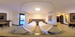 uma sala de estar com duas camas num quarto em Hotel Dolomiti Caravaggio em Nova Veneza