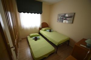 Dos camas en una habitación pequeña con ventana. en Jávea Golden Beach 1 Arenal Beach, en Jávea 20 fotos más