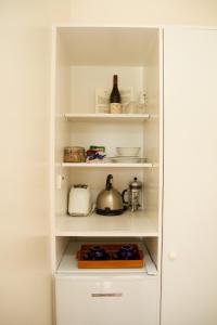 a white cabinet with a white cupboard and a white shelf at Margrain Vineyard Villas in Martinborough