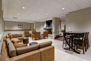 a lobby with a couch and a table and chairs at Best Western London Airport Inn & Suites in London