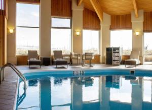 una piscina nella hall dell'hotel con sedie e tavoli di Best Western Toledo South Maumee a Maumee
