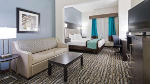 a hotel room with a bed and a couch at Best Western Waldo Inn & Suites in Waldo