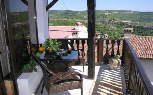 une personne sur un balcon avec une table et des chaises dans l'établissement Guest Rooms Bela Neda, à Veliko Tarnovo