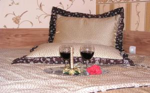 dois copos de vinho tinto sentados numa cama em Guest Rooms Bela Neda em Veliko Tarnovo