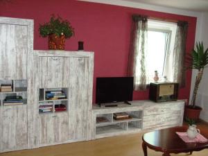 a living room with a tv and a wooden entertainment center at Ferienwohnung Örtl 7 in Obernzell