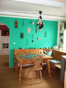 a bedroom with a wooden table and a green wall at Ferienwohnung Örtl 7 in Obernzell