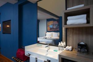 uma casa de banho com um lavatório e uma cama num espelho em Hotel G Yangon em Yangon