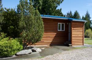 Cette petite cabane en bois dispose d'une petite fenêtre. dans l'établissement Cedar Park Resort, à Port McNeill