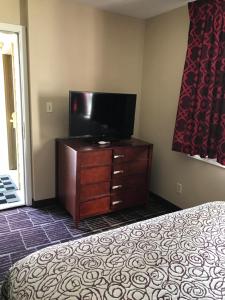 a bedroom with a bed and a flat screen tv at Economy Inn in Portland