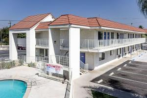 ein Gebäude mit Pool und Parkplatz in der Unterkunft Motel 6-Fresno, CA in Fresno