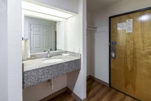 a bathroom with a sink and a mirror and a door at Motel 6-Hutchins, TX in Hutchins +21 photos