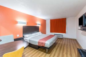 a motel room with a bed and a table and a tv at Motel 6-Hutchins, TX in Hutchins