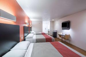 a hotel room with two beds and a flat screen tv at Motel 6-Hutchins, TX in Hutchins
