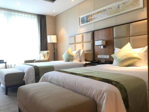 Postel nebo postele na pokoji v ubytování Kunshan Jinling Hotel