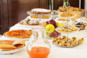 uma mesa com vários tipos diferentes de alimentos em Hotel Terra degli Elimi em Buseto Palizzolo