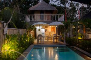 a villa with a swimming pool and a house at Kakiang Guesthouse in Nusa Lembongan