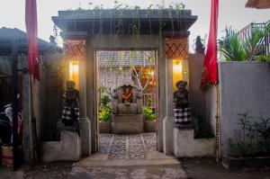 a gate to a house with two statues in front of it at Kakiang Guesthouse in Nusa Lembongan