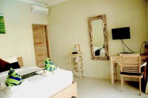 a bedroom with two beds and a mirror at Kakiang Guesthouse in Nusa Lembongan