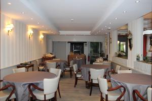 a restaurant with tables and chairs in a room at Hypnos Hotel in Hesdin