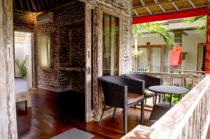 a restaurant with tables and chairs and a brick wall at Kakiang Guesthouse in Nusa Lembongan
