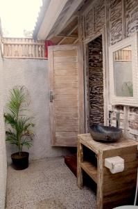 a bathroom with a sink on a wooden table at Kakiang Guesthouse in Nusa Lembongan