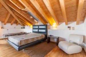 um quarto com uma cama e uma cadeira e tectos em madeira em Ex-L em Fiume Vêneto