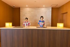 two women standing at a bar in a hotel room at Kyukamura Ibusuki in Ibusuki