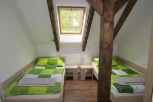 Duas camas num pequeno quarto com uma janela em Penzion Na Pohoři em Olešnice