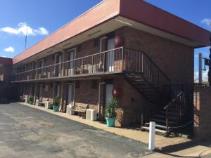 a red brick building with stairs and a balcony at Colony Inn Hotel in Jerilderie