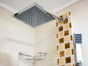 a shower head hanging from a wall in a bathroom at FaRoyal Luxury Suite in Eilat +15 photos