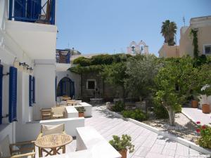 a patio with tables and chairs and a building at Captain Manolis in Parikia