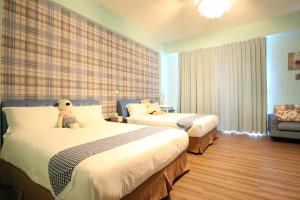a hotel room with two beds with a teddy bear on them at Baby Pig B&B in Taitung City