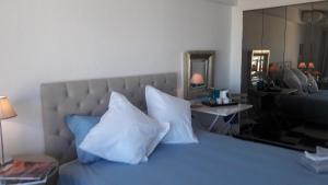 a bedroom with a blue bed with white pillows at Luxury Homestay Le Piree in Antibes