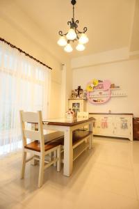 a kitchen with a dining room table and a chandelier at Baby Pig B&B in Taitung City
