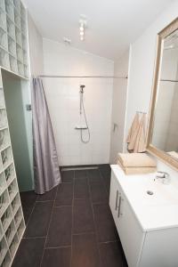 a white bathroom with a shower and a sink at Kerteminde Byferie - Hyrdevej 83, 85B in Kerteminde