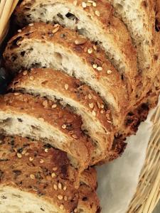 a pile of bread with sesame seeds in a basket at Ferme Des Chartroux in Maresville