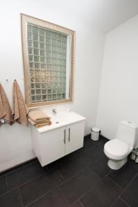a bathroom with a toilet and a sink and a window at Kerteminde Byferie - Hyrdevej 83, 85B in Kerteminde