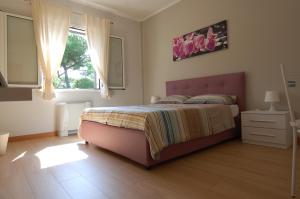 a bedroom with a large bed and a window at Vacanze Romane Olgiata in La Storta