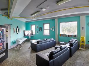 Noahs Bondi Beach في سيدني: غرفة معيشة مع جدران زرقاء وأرائك جلدية