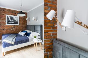 a bedroom with a bed and a brick wall at Sanhaus Apartments - Apartamenty Sailor in Sopot