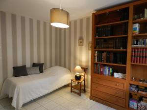 a bedroom with a bed and a book shelf at La Sembelie in Carsac-Aillac